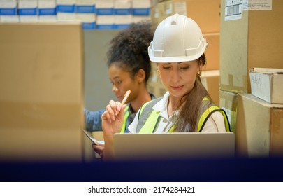 Two Female Warehouse Worker Counting Items In An Industrial Warehouse On The Factory's Mezzanine Floor. Which Is A Storage For Small And Light Electronic Parts.