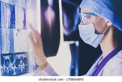 Zwei weibliche Ärztinnen, die Röntgenaufnahmen in einem Krankenhaus betrachten.