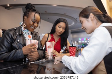 Two females choosing movietheatre seat from Cinema ticket seller counter