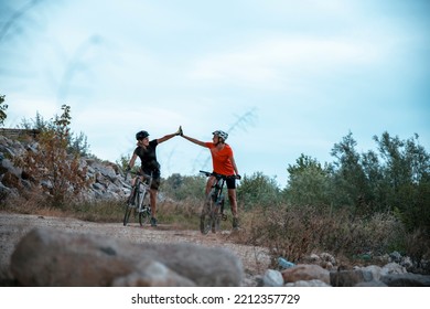 Two Females High Five On Mountain Bike Ride. Happy Senior Women Cyclist Celebrating Success On Riding In Wilderness. Copy Space