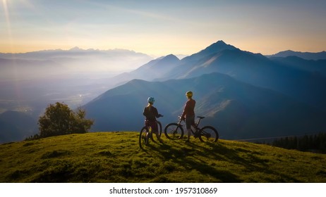 Two females on mountain bikes talking and looking at beautiful sunset - Shutterstock ID 1957310869