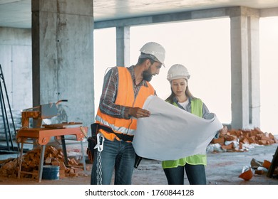 Two Field Service Engineer In The Construction Industry To Discuss The Construction Plan. Concentrated Builders Working Together On A Project