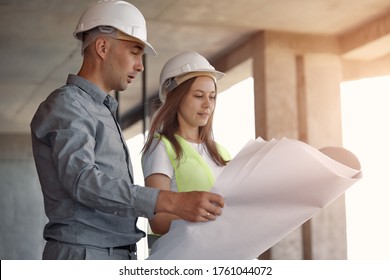 Two Field Service Engineer In The Construction Industry To Discuss The Construction Plan. Concentrated Builders Working Together On A Project