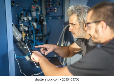 Two Field Service Maintenance Engineer Technician Electrician Inspect And Control Machine Hardware And Software System With Laptop Computer. Electric Installation