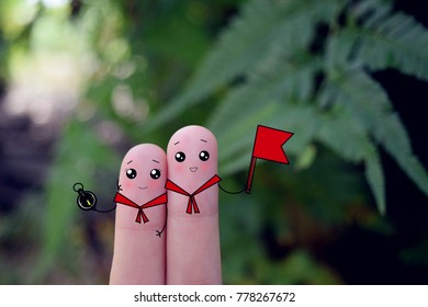 Two Fingers Decorated As Two Boy Scouts. One Of Them Is Holding Compass And Another One Is Holding A Red Flag.