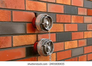 Two fire hydrants pulled out of a brick wall