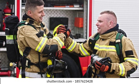 Two firefighters shaking hands after successful fire drill. High quality photo