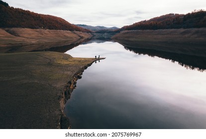 Two Fisherman Fishing In Half Dry Lake. Cinematic View. Late Autumn. Cloudy Movie Scene.Wallpaper