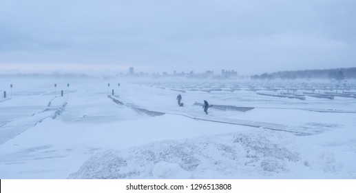 Two Fishermen Going Ice Fishing During A Winter Storm At The Small Boat Harbor In Buffalo.  Buffalo, New York, USA, January 27th 2019