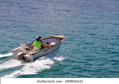 Two Fishermen Returning Home In S Water Beaten Fishing Skiff Powered By An Outboard Engine.