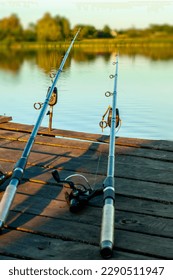 two fishing rods on an old fisherman's bridge on the river, a man's rest, a beautiful landscape, a blurred background. High quality photo