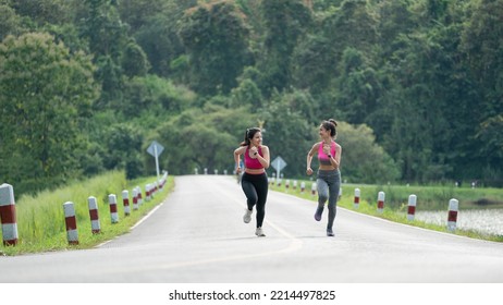 Two Fit Female Runners Talking Happy And Smiling During Workouts.