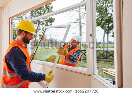 Two fitters from Glaserei build windows when building a house on a construction site
