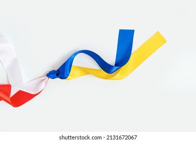 Two flags Poland and Ukraine tied to a knot on the white background. The friendship and donation from Poland to Ukraine during the War