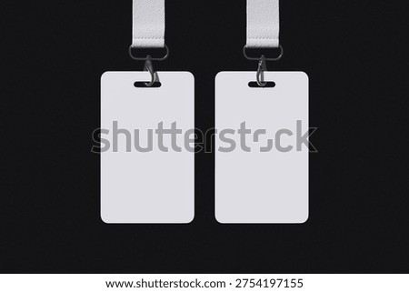 Two floating white ID Card with lanyard on black background for mockup template