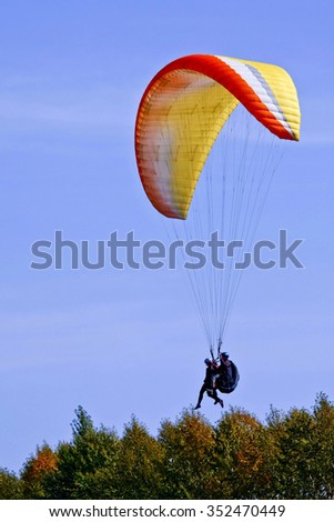  Two fly by  on a paraplane over frees.
