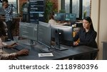 Two focused coders facing each other writing code in software development office while team of coders are developing artificial intelligence. Team of programmers innovating algorithm code.