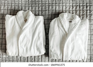 Two Folded White Bathrobe On Hotel Bed Blanket. Cotton Bath Robe For Couple In Spa. Fluffy Massage Clothing On Valentines. Valentine Day Leisure Concept.