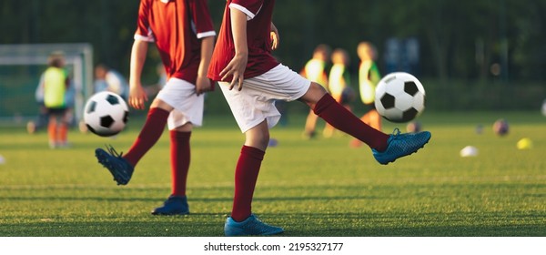 Two football players juggle soccer balls. Kids practicing soccer on grass pitch - Powered by Shutterstock