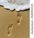 two footstep imprints on a beach