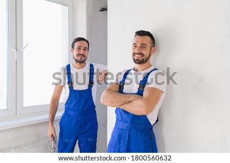 Two foremen in uniform look at the camera