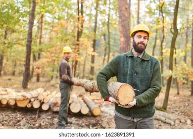 Two forest workers transport a tree trunk together during the harvest - Powered by Shutterstock