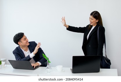 Two Formal Smart Asian Colleague Businessman And Woman Smiling With Happiness, Waving Hands For Goodbye After Finishing Work, Standing In Modern Indoor Office