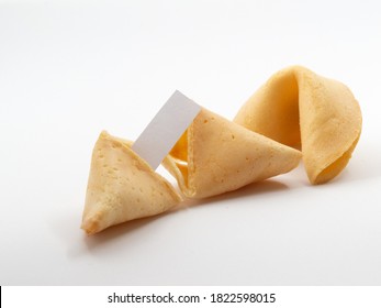 Two Fortune Cookies With One Opened And A Small Blank Piece Of Pager Visible In Front Of White Background