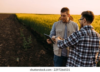 Two framers using technology to do some analysis on the oilseed rape plant