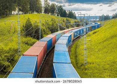 Two freight trains move in parallel, carrying colorful containers along railway tracks. Set against a backdrop of vibrant green hills, the natural beauty enhances the scene as the trains