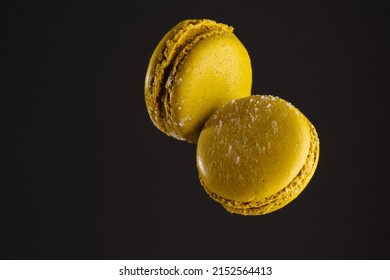 Two French Macaroons In A Frozen Flight On A Black Background. Minimalism. Sweet Food, Calories, Holiday, Birthday, Romantic Date. There Are No People In The Photo. There Is Free Space To Insert.