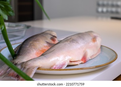 Two Fresh Cleaned Arctic Char Fish On A Blue Plate On A White Ta