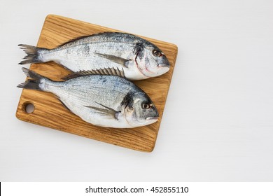 Two Fresh Dorado Fish On Wooden Cutting Board.  Top View, Copy Space. 