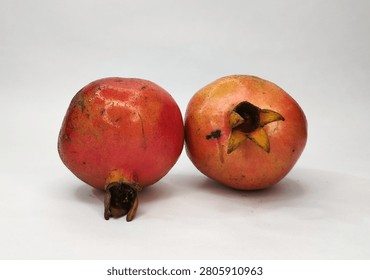 Two fresh red apples with stems and a single leaf, isolated on a plain white background in sharp focus.