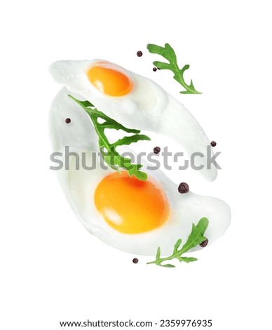 Two fried eggs with arugula close up in the air isolated on a white background