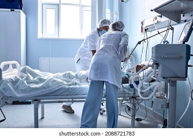 Two friendly doctors nurses help injured sick person, in hospital ward room. covid-19 patient with medical equipment, injected, under dropepr. on bed in hospital, coronavirus concept. - Shutterstock ID 2088721783