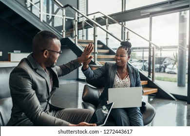 Two Friendly Smiling African Business People Celerbarting Their Sucess With A High Five