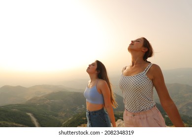 Two friends breathing fresh air relaxing in the mountain on summer - Powered by Shutterstock