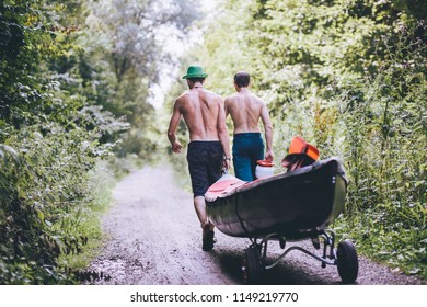 two friends carrying their kayaks towards the river - Powered by Shutterstock