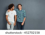 Two friends in casual wear standing and laughing together. Best friends enjoying isolated over grey background. Two men having fun isolated over grey wall with copy space.