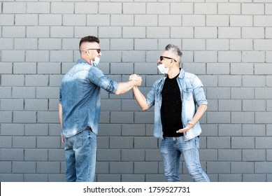 Two Friends Doing Greetings With Handshake After Coronavirus Outbreak - Men With Lowered Protective Masks - Two Friends Who No Longer Respect Social Distancing - New Normal Concept After Pandemic