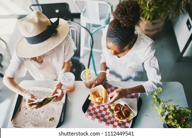 Two Friends Eating Healthy Vegan Food At Restaurant Together