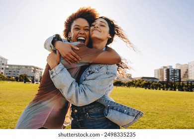 Two friends embracing and celebrating their friendship in the park on a sunny day. Happiness and joy in their expressions. - Powered by Shutterstock