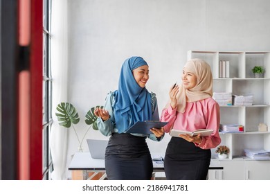 Two Friends Female Charming Asian Muslim Lady Wearing Hijab Working And Discussing At Meeting In Office.