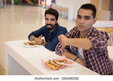 Two Friends In The Food Court, One Thumb Up Happy With The Good Salad, One Thumb Down Sad Of The Bad Pizza Slice.