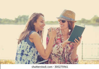 Two Friends Happy Students Women Studying Reading Book Outdoors On Summer Sunny Day 