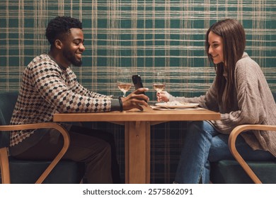 Two friends are having dinner at restaurant. They are sitting, talking and enjoying time together.