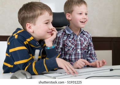 Two friends are having fun while working on a computer.