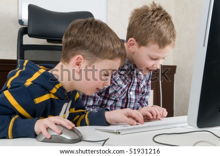 Two friends are having fun while working on a computer.
