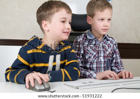 Two friends are having fun while working on a computer.